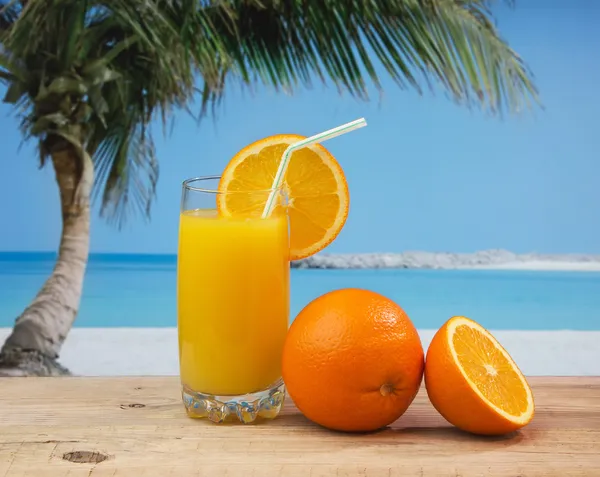 Glass of orange juice on a beach