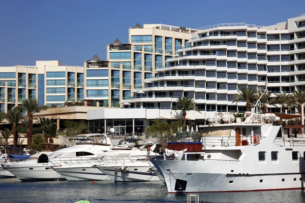 Luxury Yachts Docked In Front Of Waterfront Hotels
