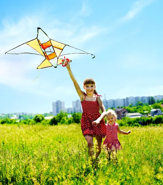 Group children flying kite outdoor.