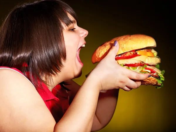 Hungry woman holding hamburger.