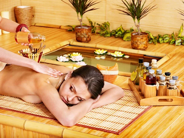Woman getting massage in bamboo spa.