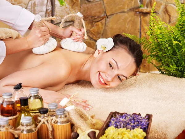 Woman getting thai herbal compress massage .