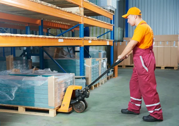Worker with fork pallet truck