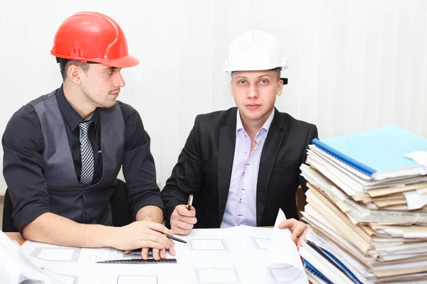 Architect and construction engineer discussing plan in office room