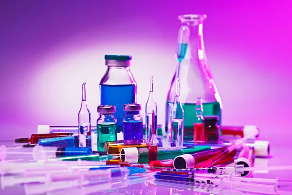 Medical laboratory glass equipment still life on blue purple