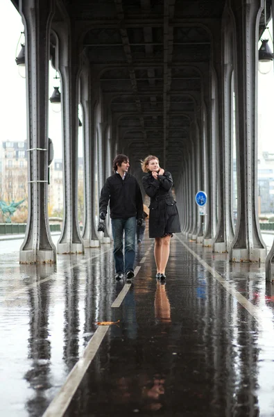 Bad weather in Paris. Couple on the Bir-Hakeim bridge at rain