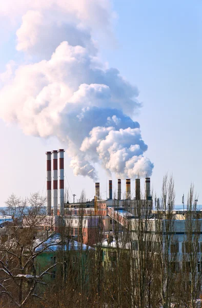 Large factory with smoking chimneys against the blue sky