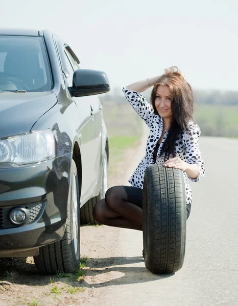 Woman changing car wheel