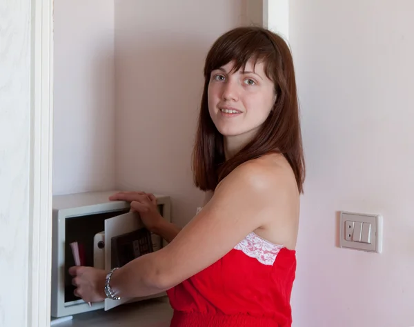 Woman puts documents in safe