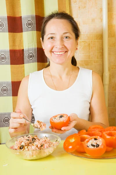 Female cook stuffing tomato