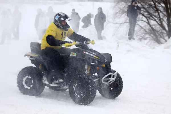The quad bike's driver rides over snow track