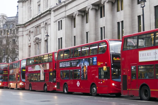 Double Decker red bus rides on the street in London