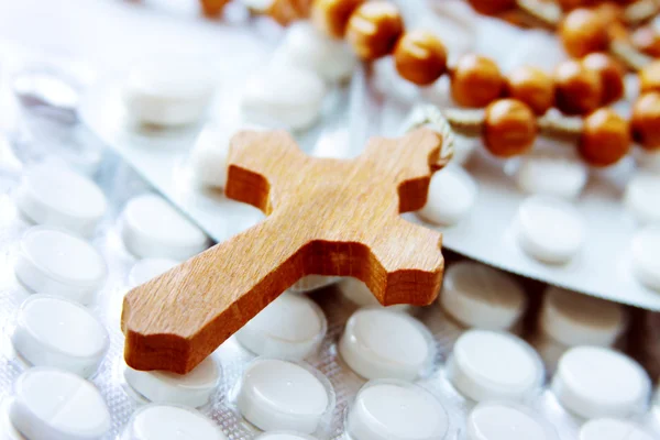 Wooden cross on packages of pills