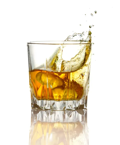 Splash in glass of whiskey and ice isolated