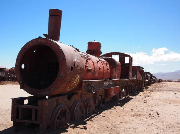 Rusty old steam locomotive and train in the desert