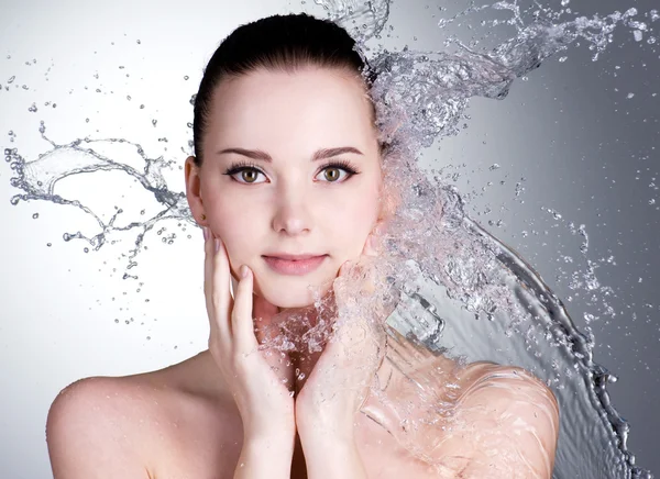 Splashes of water on the face of beautiful sexy woman