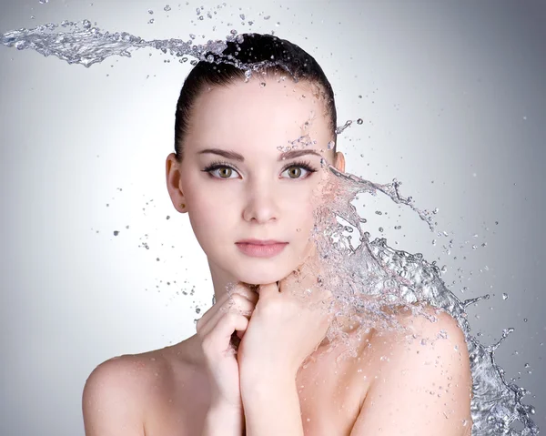 Beautiful woman with clean skin with splashes of water