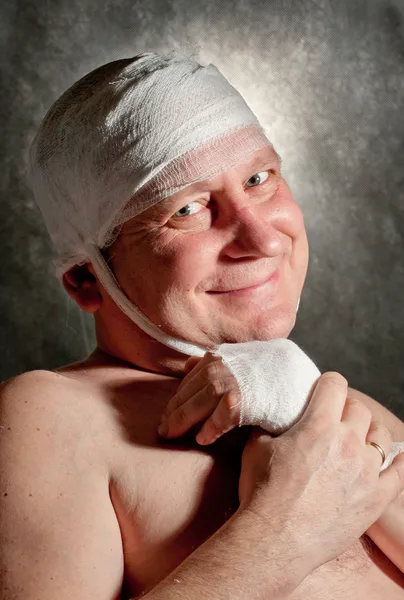 Man with bandage on head. Looking unhappy at something.
