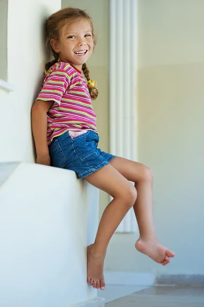 Little girl in shorts sitting