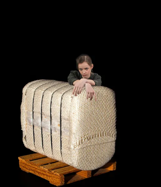 Teenage Woman Leaning on Cotton Bale on a Pallet