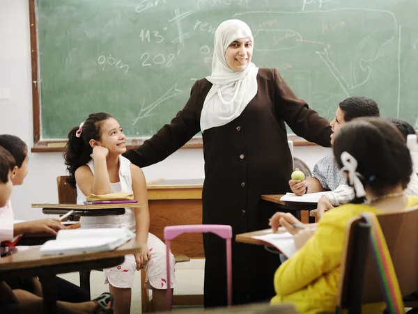Muslim arabic children with teacher at school