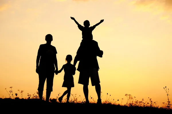 Silhouette, happy children with mother and father, family at sunset, summer