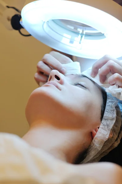 Woman with facial mask in cosmetic studio