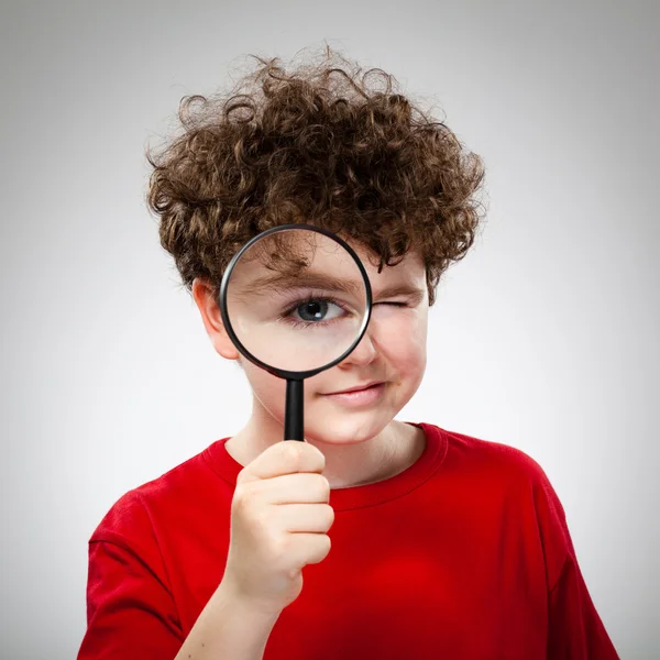 Boy looking through magnifying glass