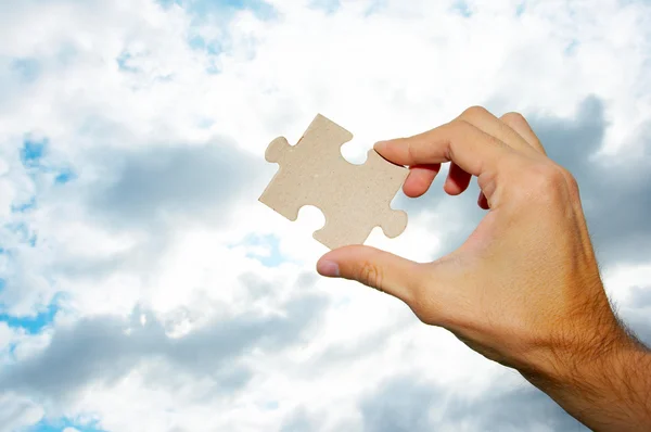 The hand holds puzzle on a background of the sky — Stock Photo #10514503