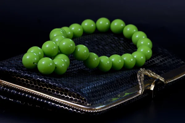 Green beads and a black handbag
