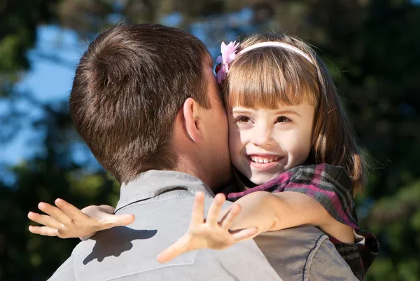 Beautiful little girl hugging embracing her father
