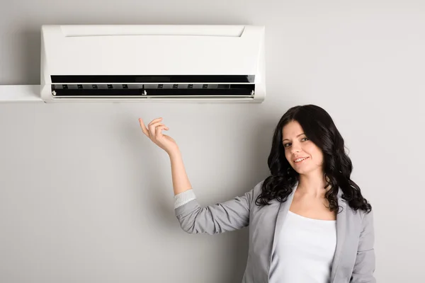 Young woman showing air conditioner
