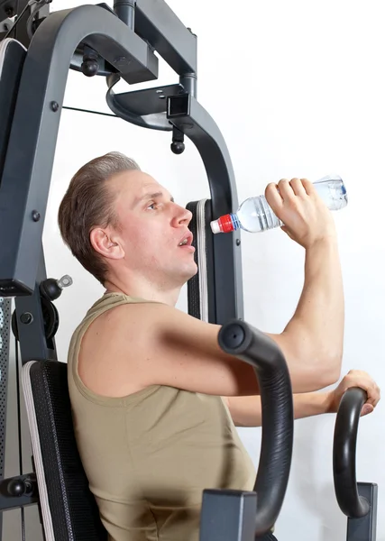 Young man drink water at fitness training
