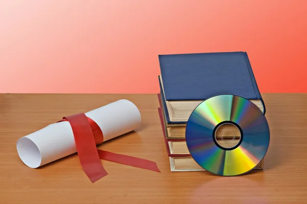 Scroll with red ribbon and books