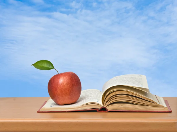 Red apple and book on desk