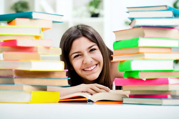 Teenage girl between stack of book