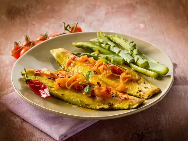 Fish fillet with tomato hot chili pepper and asparagus
