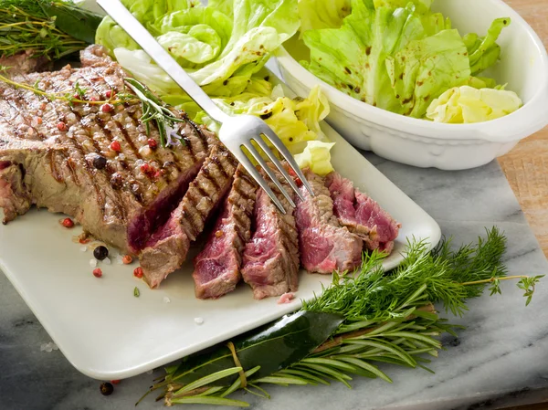 Sliced steak with green salad