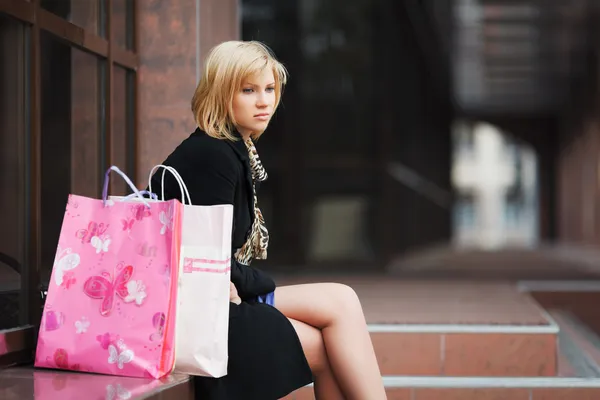 Sad young woman with shopping bags