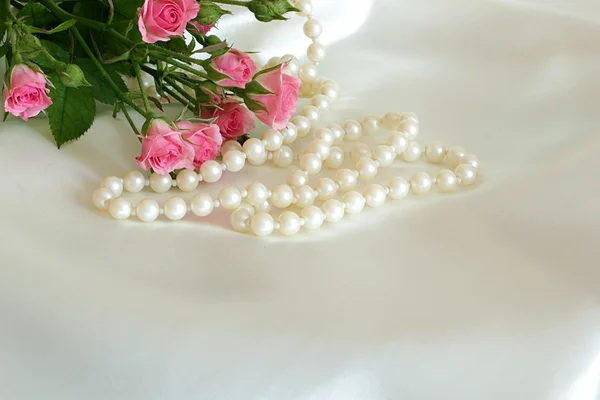 Roses and pearls on the white silk