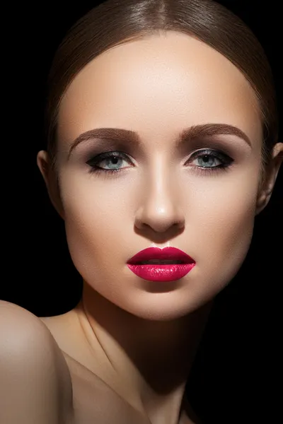 Sexy woman model with bright fuchsia lips makeup, strong eyebrows & cheekbones and healthy shiny skin. Evening glamour style, fashion make-up