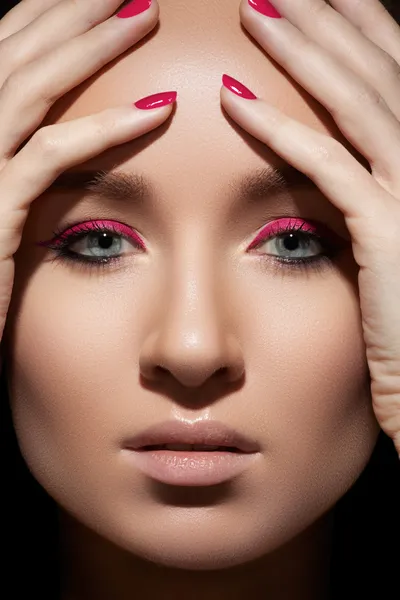 Beautiful close-up portrait of fashion woman model with glamour magenta makeup, pale lips, bright pink nail polish. Fresh style, visage and manicure