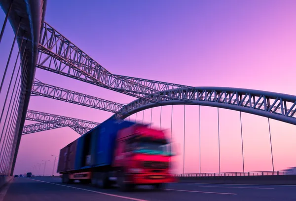 Truck speeding through a bridge at sunset,motion blur.
