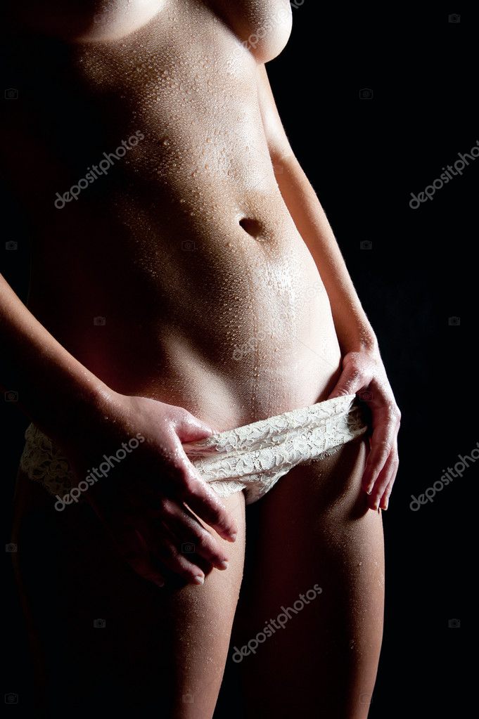 Young woman taking off beautiful white panties in front of black background