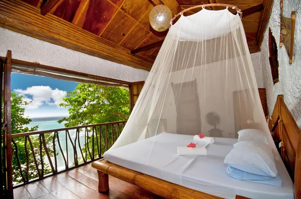 Bedroom with canopy bed with sea view