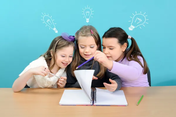 Three happy girls doing their school work
