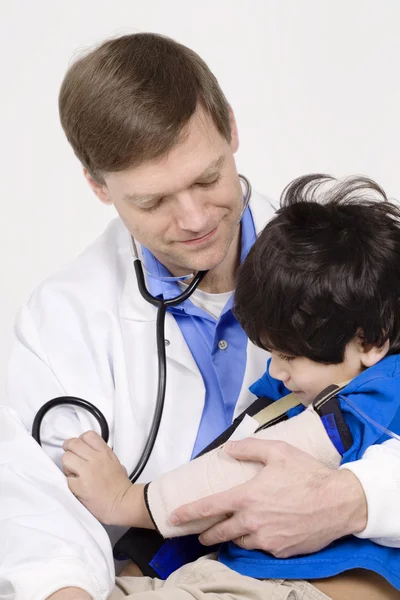 Male doctor interacting with disabled toddler patient on lap