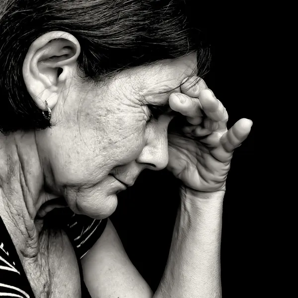 Black and white portrait of a very sad old woman
