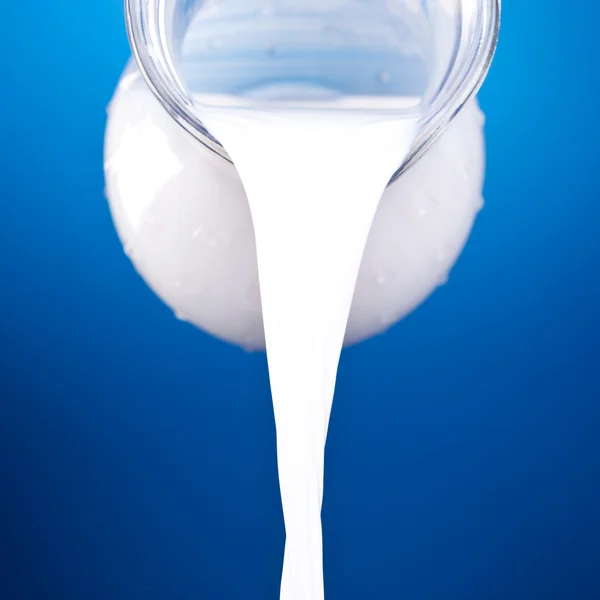 Closeup of a jug with pouring milk