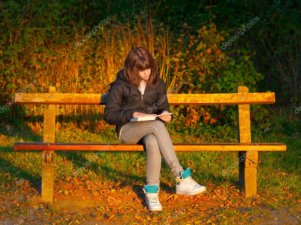 Schöner Teenager Mädchen Liest Das Buch Beim Sitzen Auf Der Bank — Stockfoto © Prudkov 8174476 